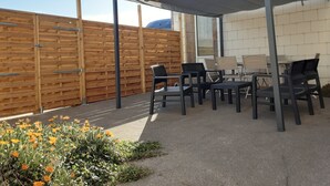 An outdoor patio with a wooden fence, a covered seating area, and a flower bed. - Seaside house 6 pers. Trébeurden pink granite coast Brittany (Trébeurden)