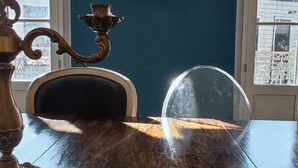 A dining table with a clear glass top, a candle holder, and a chair. A framed picture hangs on the wall above the table. - Charming house downtown ARCEAUX 140M2. 4 bedrooms. Possible Prkg (Montpellier)
