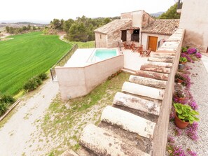 Eine Villa mit Swimmingpool, Steinstufen und Blick auf die Landschaft.