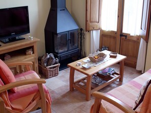 Una sala de estar acogedora con televisión, chimenea y asientos cómodos.