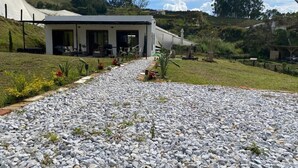 Um edifício moderno com um caminho de cascalho que leva a uma área de estar coberta ao ar livre.
