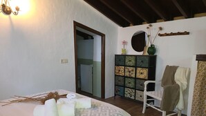 Un dormitorio con cama, cómoda, silla y espejo.