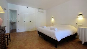 A bedroom with a large bed, a wardrobe, and a small table. - Costa del Sol Villa Near Beach (San Pedro de Alcantara)