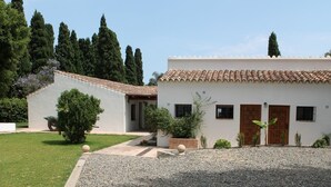 A two-story building with a tiled roof, a gravel driveway, and a well-maintained lawn. - Costa del Sol Villa Near Beach (San Pedro de Alcantara)