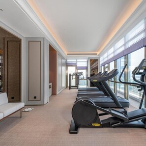 A modern gym with treadmills, a weight bench, and a bench press. - Mercure Guangzhou Financial City (Guangzhou)