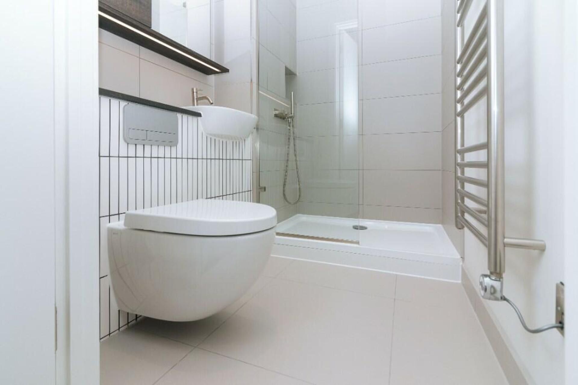 A modern bathroom with a toilet, sink, and shower area.