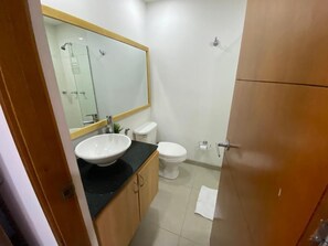 A bathroom with a white sink, a mirror, a toilet, and a shower. - Luxury Town Great Central View Duplex Coworking Tourist Area (Medellín)