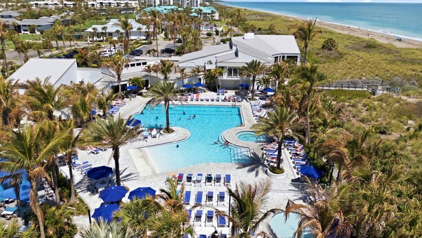 A resort with a central swimming pool, lounge areas, and a beach view. - Your Perfect Vacation Townhome Just Steps from the Sand! - Full Amenities (Fort Pierce)