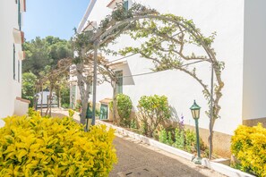 Stroll through this serene courtyard, surrounded by lush greenery and a charming archway.