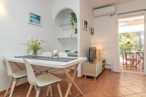 Relax in this open-plan living and dining area, featuring a dining table, comfortable seating, and a sliding door to an outdoor space.