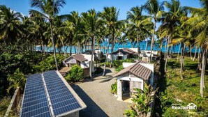 A resort with multiple bungalow-style buildings, a solar panel, and a view of the ocean. - Casa Taina- 5 Bungalows, swimming pool- OCEANFRONT w/Butler and Chef (Cabrera María Trinidad)