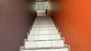 Una scala con gradini bianchi e un muro rosso.