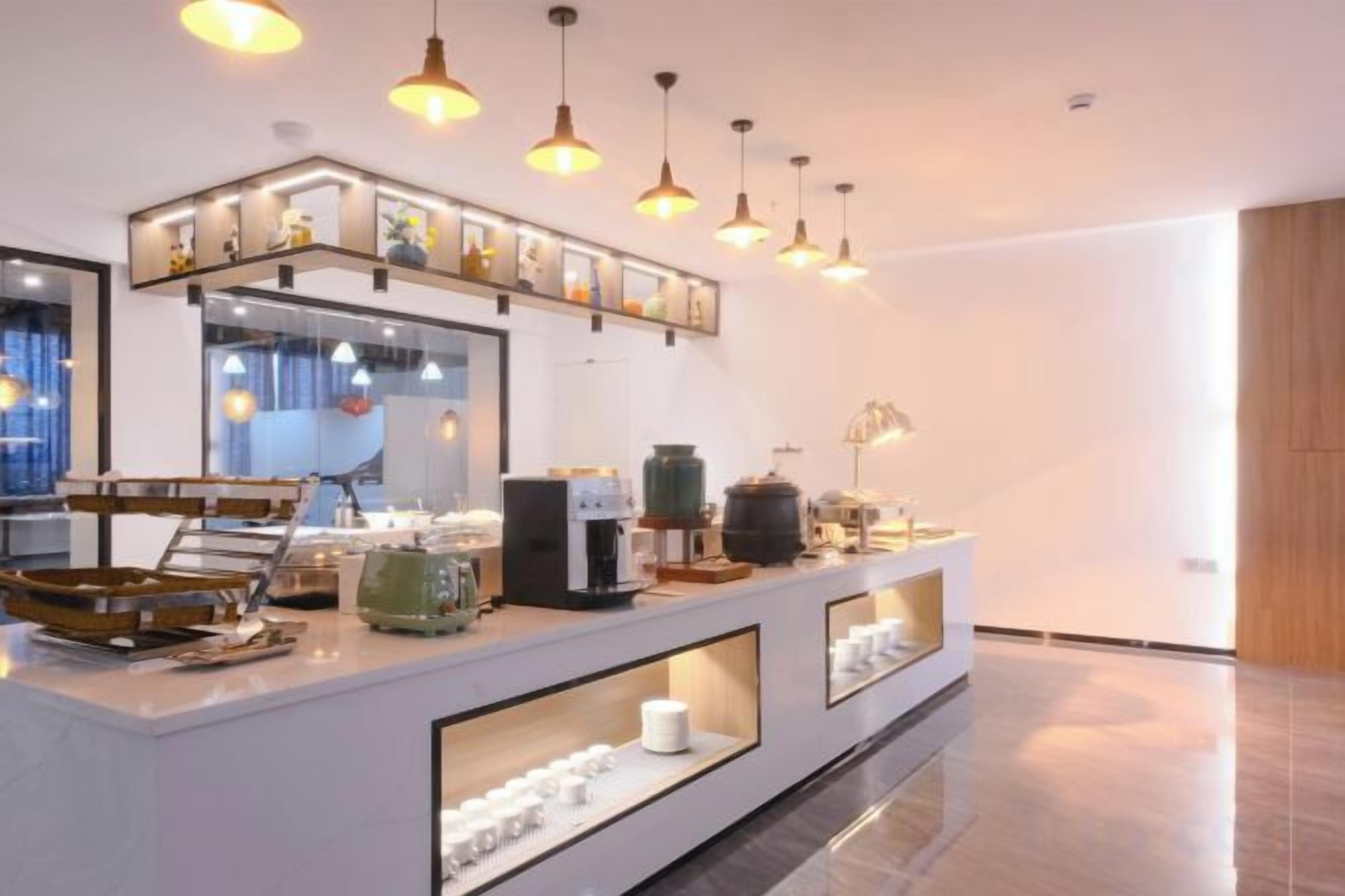 Una barra de desayuno moderna con una máquina de café, estaci ón de té y vitrinas de vidrio.