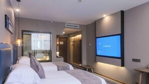 Une chambre d’hôtel avec deux lits, une télévision, un bureau et une salle de bain.