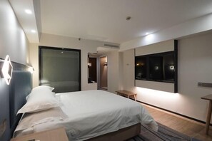 A modern hotel room with a large bed, a bedside table, a mirror, and a TV. - Jinglan Yipin Hotel (Jingdezhen Taoxichuan Branch) (Jingdezhen)