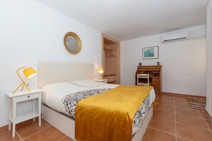 Cozy retreat with a neatly made bed, bedside table, and wardrobe.