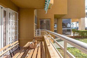Enjoy the serene view from this balcony, featuring a comfortable bench and a charming cactus plant.