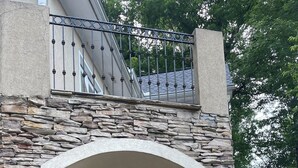 A covered patio with stone walls, a ceiling fan, and outdoor furniture. - River tunes at its best panoramic views just steps away from the river  (Ellijay)