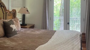 A bedroom with a large bed, a ceiling fan, a window with blinds, and a view of trees outside. - River tunes at its best panoramic views just steps away from the river  (Ellijay)