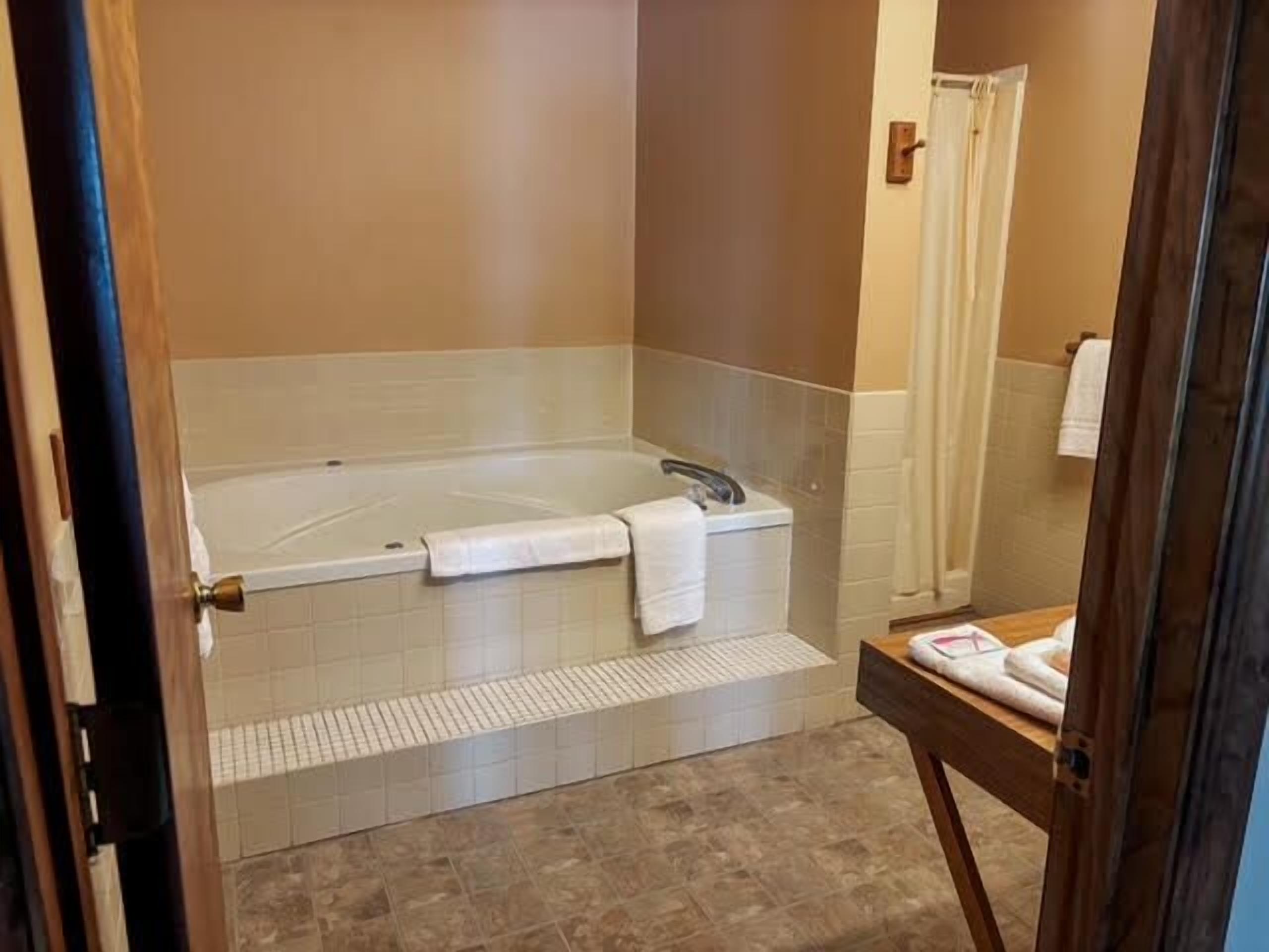 Une salle de bain équipée d’une baignoire, d’une douche et d’un meuble-lavabo avec une serviette.