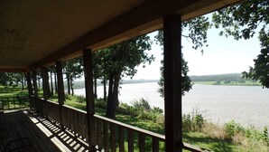 A wooden deck with a railing overlooking a lake, surrounded by trees. - Deluxe Suite - Bungalow overlooking on the Bluff! (Stone Church Precinct)