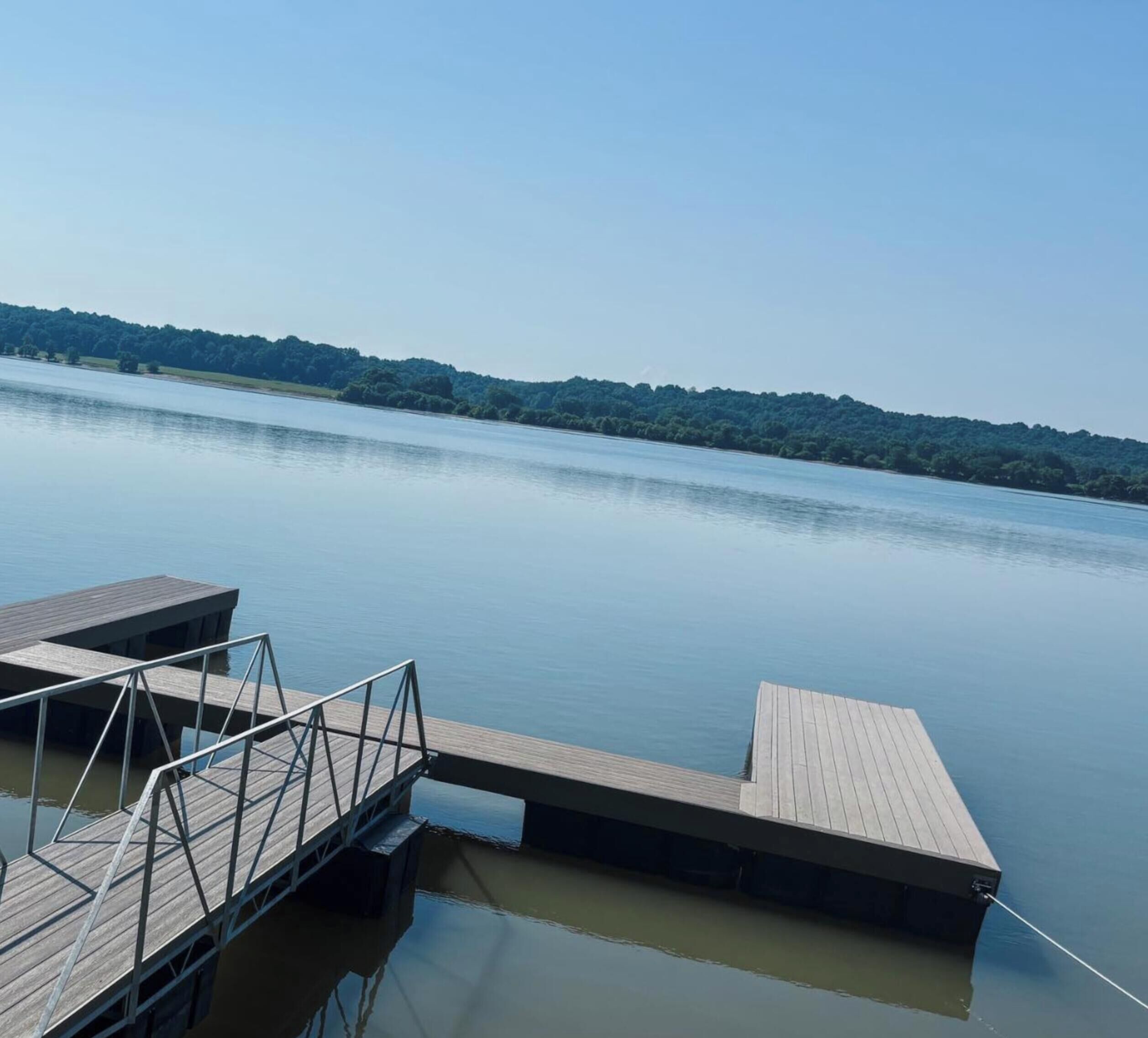 Un lago tranquilo con un muelle de madera que se adentra en el agua.