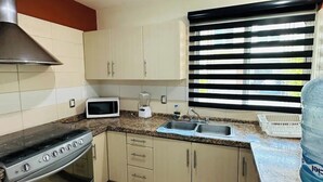 Une cuisine équipée d’une cuisinière, d’un four à micro-ondes et d’un évier.