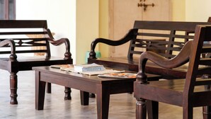 A wooden dining table with two chairs, a book, and a woven placemat. - Urban Trippers Shamiyana Villa byArindam (Jaipur)