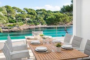 Dine with a serene view overlooking the water and lush greenery.