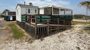 Una casa móvil con terraza de madera y porche cubierto.