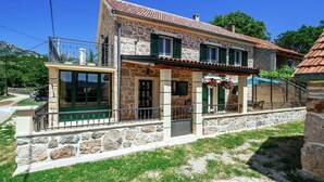 A stone house with a balcony, a small porch, and a tiled roof. - Holiday Home Zaton with Pool near River Canyon (Obrovac)