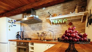 A kitchen with a wooden countertop, stainless steel appliances, a brick backsplash, and a fruit display. - Holiday Home Zaton with Pool near River Canyon (Obrovac)