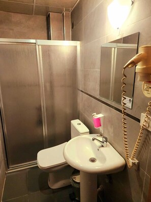 Een douche, een haardroger, pantoffels, handdoeken