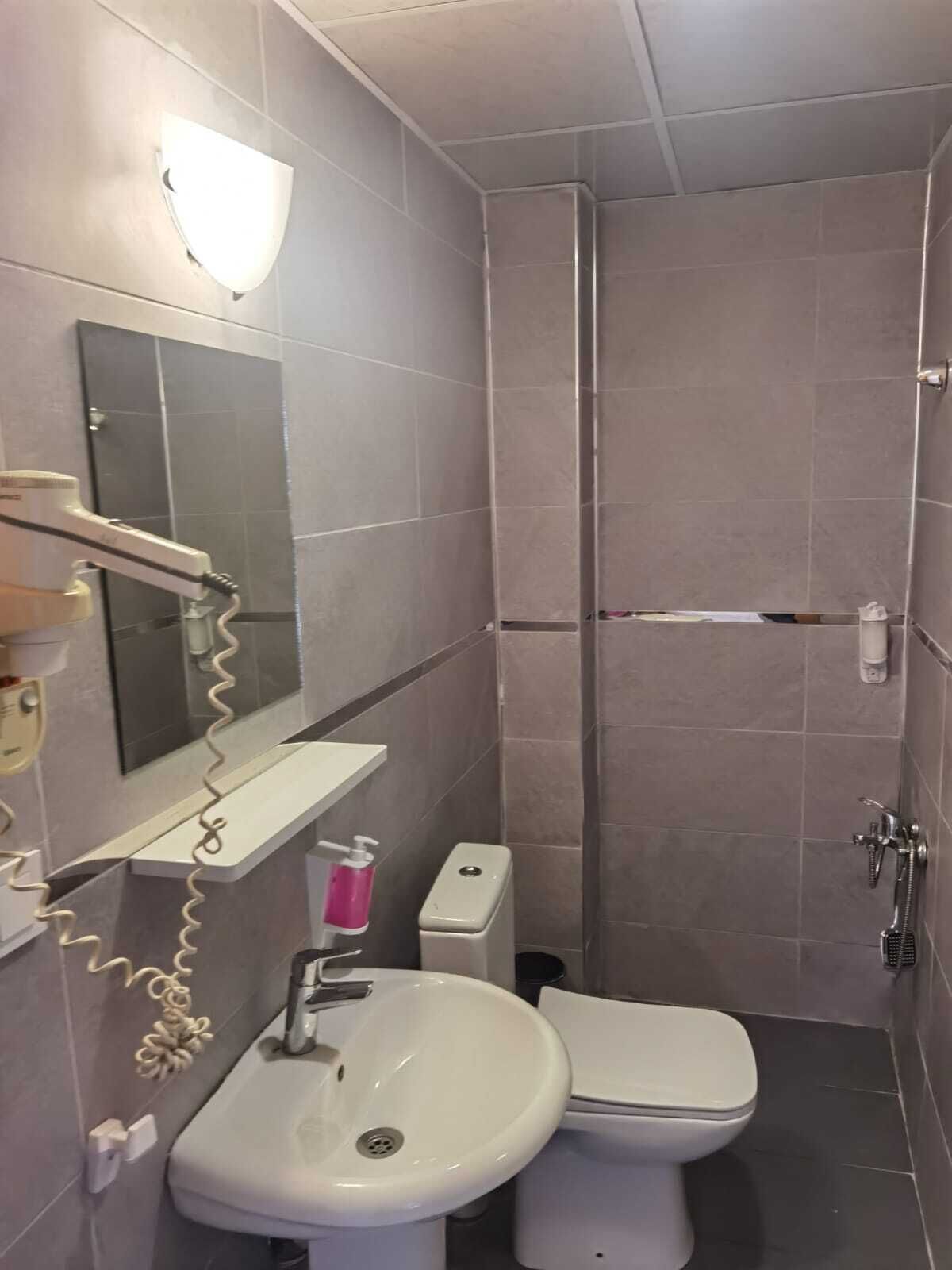 Un bagno piccolo e moderno dotato di doccia, WC e lavandino.