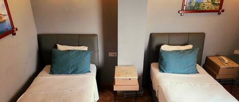 Une chambre d’hôtel avec deux lits, chacun doté d’une tête de lit, d’une table de chevet et d’une lampe.