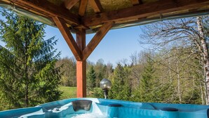 A hot tub under a wooden pergola with a view of a forested area. - Holiday Home in Gorski Kotar with Pool (Brod Moravice)