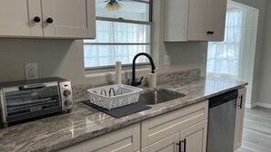 A kitchen with a built-in toaster, a sink, and a dishwasher. - Cozy Home In Beverly Hills near Crystal River, Florida (Beverly Hills)
