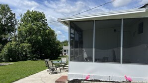 A modern house with a covered patio, a lawn, and a large window overlooking the yard. - Cozy Home In Beverly Hills near Crystal River, Florida (Beverly Hills)