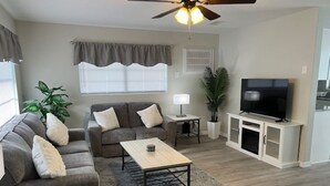 A living room with a sofa, coffee table, TV, and a ceiling fan. - Cozy Home In Beverly Hills near Crystal River, Florida (Beverly Hills)