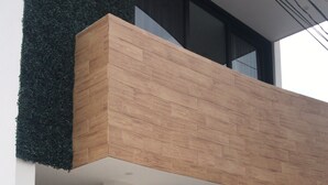 Ein modernes Gebäude mit flachem Dach, großen Glasfenstern und einer Holzfassade.