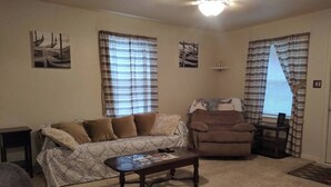 A living room with a sofa, armchair, coffee table, and a ceiling fan. - Cozy 2-bedroom bungalow with AC and WiFi in charming Springfield (Springfield)