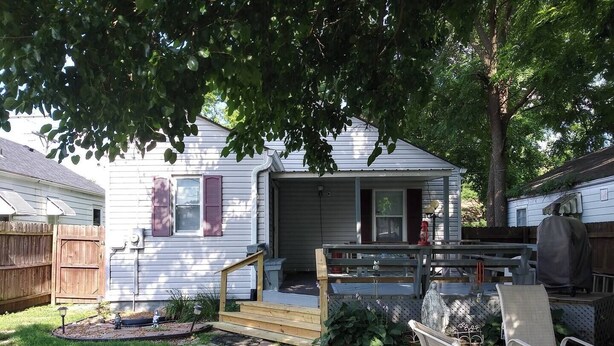 A residential backyard with a wooden deck, a small garden area, and a covered outdoor seating area. - Cozy 2-bedroom bungalow with AC and WiFi in charming Springfield (Springfield)