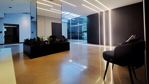 A modern interior with a reception desk, a seating area, and a glass partition. - Saint Sebastian ap103-stúdio  (Jaragua do Sul)