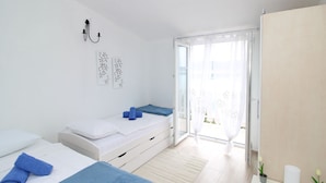 Une chambre à coucher moderne avec un lit, une table de chevet et une vue à travers une porte vitrée.