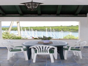 A round table with white chairs and a view of a lake with boats. - Holiday Home in Veli Rat near Saharun (Veli rat)