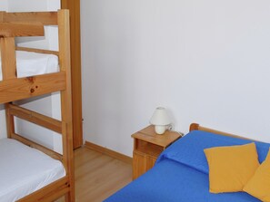 A bunk bed with a white mattress, a bedside table with a lamp, and a bed with a blue mattress and yellow pillow. - Holiday Home in Veli Rat near Saharun (Veli rat)