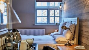 Une chambre d’hôtel bien aménagée, avec un lit, une table de chevet, une lampe et une fenêtre donnant sur un beau paysage.