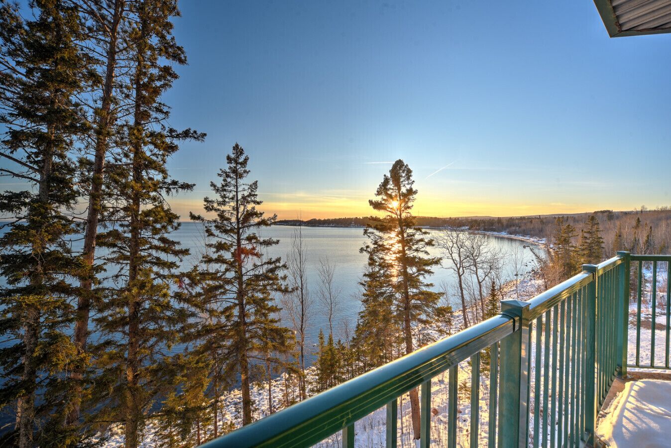 Ein Balkon mit Blick auf einen See und Bäume.