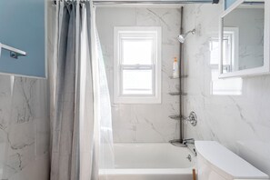 A bathroom with a bathtub, a shower, and a sink. - Wells Whole House (Bridgeport)