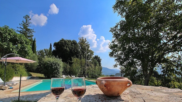 Une table avec un saladier, deux verres à vin et plusieurs pommes.